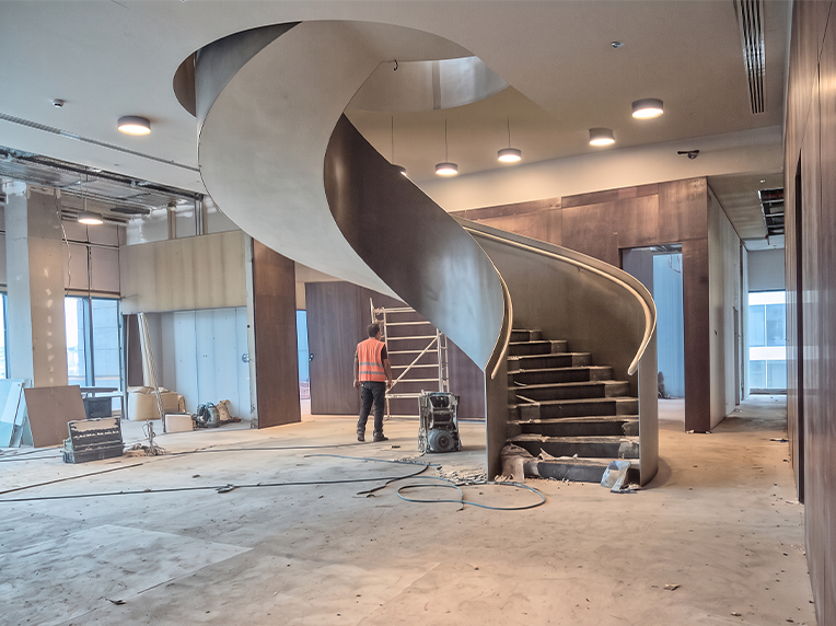 Escalier colimaçon métallique sur mesure intégré dans une trémie ronde en béton