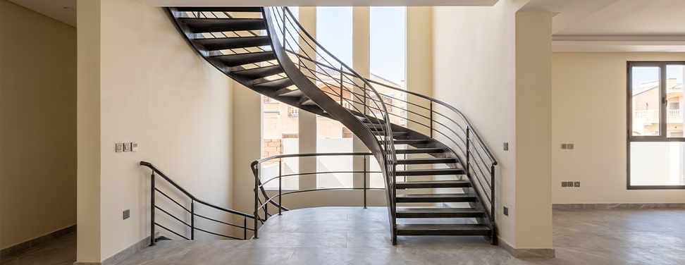 Escalier hélicoïdal métallique sur mesure intégré dans un espace contemporain vitré