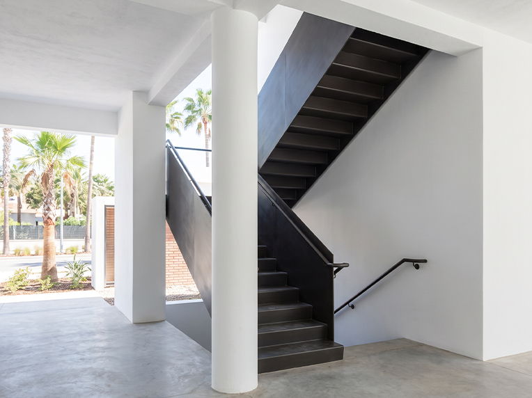 Escalier métallique noir sur mesure reliant les différents niveaux d’une villa contemporaine