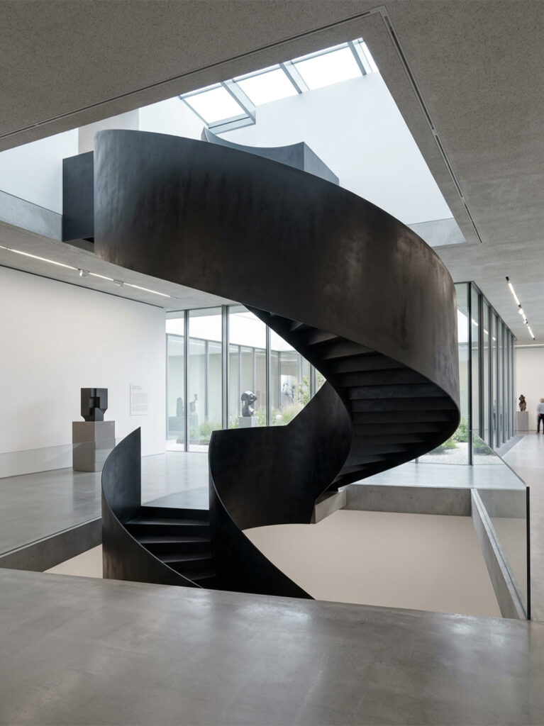 Escaliers colimaçon métalliques noirs intégrés dans un espace architectural contemporain