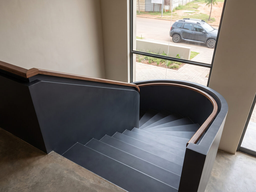 Escaliers hélicoïdaux sur mesure avec marches métalliques noires et garde-corps continu